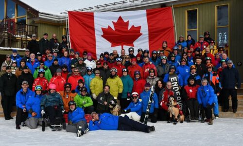 2020-WSC-group-shot Large group of Winter Sports Clinic Participants smiling with a Canadian flag